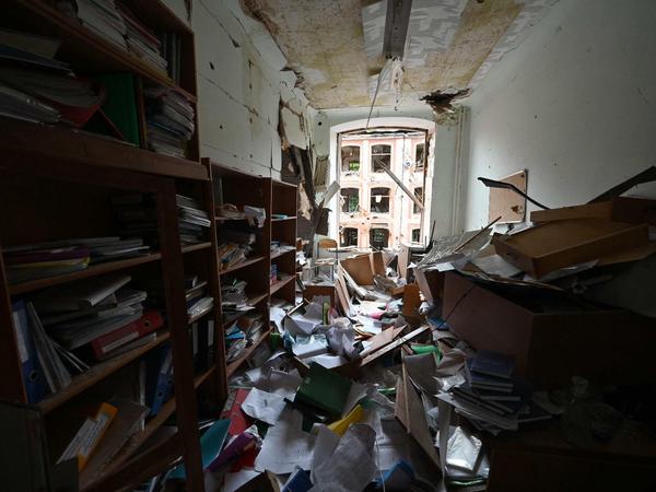 Ein Büro in einer Universität, in dem die Decke heruntergekommen und Bücherregale in den Raum gekippt sind.
