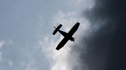 Ein Kleinflugzeug fliegt vor dunklen Wolken (Symbolbild)