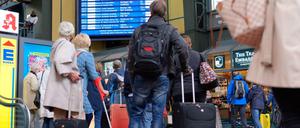 Zahlreiche Reisende vor einer Anzeigetafel mit An- und Abfahrtszeiten der Züge am Hamburger Hauptbahnhof.