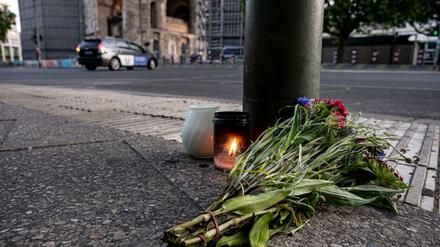 Kerzen und ein Blumenstrauß liegen auf dem Bürgersteig an der Tauentzienstraße.