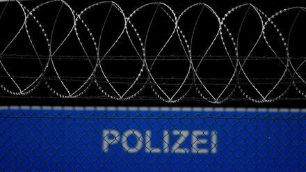 Ein Bus der Bundespolizei mit der Aufschrift Polizei steht hinter einem Sicherheitszaun auf dem Gelände des Flughafens. 