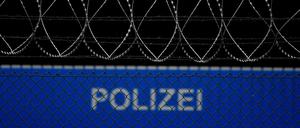Ein Bus der Bundespolizei mit der Aufschrift Polizei steht hinter einem Sicherheitszaun auf dem Gelände des Flughafens. 