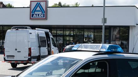 Einsatzfahrzeuge der Polizei stehen vor dem abgesperrten Discounter.