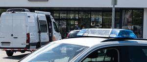Einsatzfahrzeuge der Polizei stehen vor dem abgesperrten Discounter.