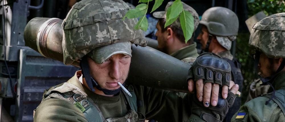 Ein ukrainischer Soldat mit Raketen für eine amerikanische M777 Haubitze im Donbass.