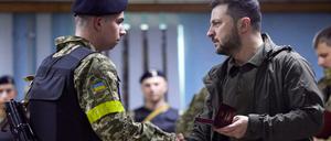 Wolodymyr Selenskyj (r.) zeichnet in Charkiw einen Soldaten aus.