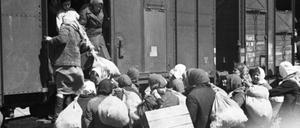 Frauen und Mädchen, die unter deutscher Bewachung in einen Waggon steigen, um zur Zwangsarbeit nach Deutschland verschleppt zu werden, aus der Ukraine im Frühjahr 1943.