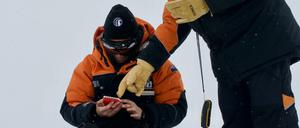 Alex Aves (l.) von der Canterbury University notiert Daten während der Probennahme von Schnee in der Antarktis. 