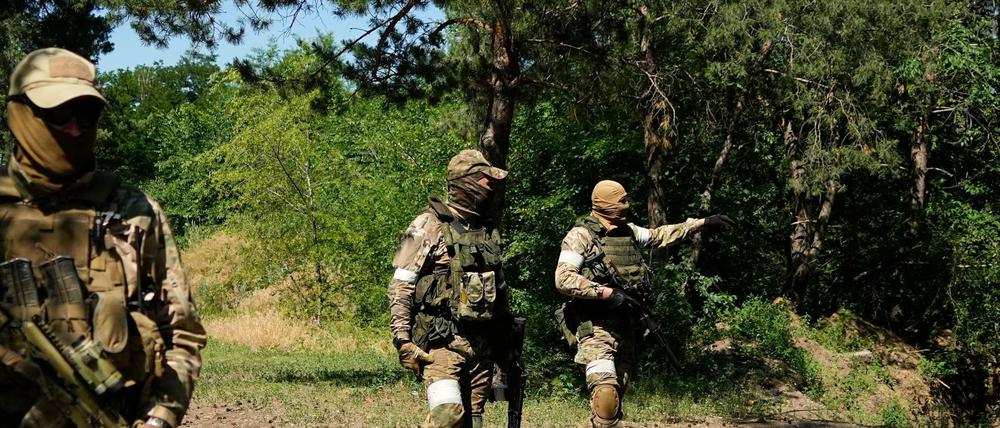 Russische Soldaten gehen an einem eroberten ukrainischen Kontrollpunkt entlang in der Nähe der Stadt Schtschastja.