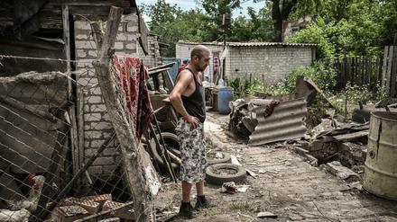 Ein Mann zwischen den Trümmern seines Haus in einem Ort im Donbass
