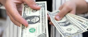 Eine Frau hält Dollar-Scheine in der Hand.
