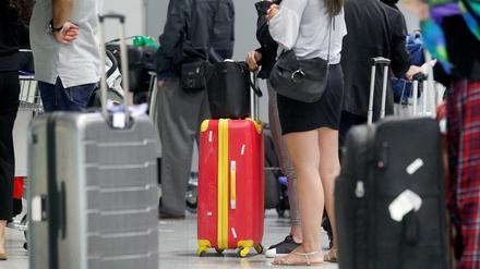 Fluggäste warten am Düsseldorfer Flughafen vor einem Check-In-Schalter auf ihre Abfertigung (Archivfoto).