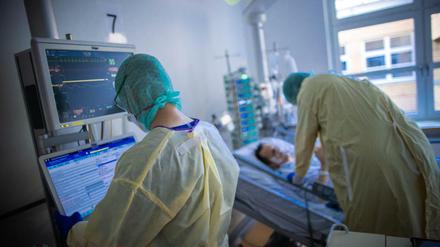 Pflegekräfte betreuen im besonders geschützten Teil einer Intensivstation einen Covid-Patienten.