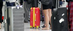 Fluggäste warten am Düsseldorfer Flughafen vor einem Check-In-Schalter auf ihre Abfertigung. 