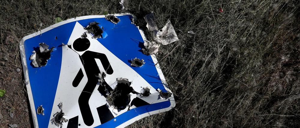 Ein Straßenschild, das durch Streumunition beschädigt wurde, liegt am Stadtrand von Charkiw.