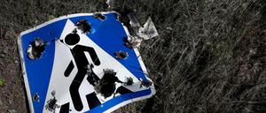 Ein Straßenschild, das durch Streumunition beschädigt wurde, liegt am Stadtrand von Charkiw.