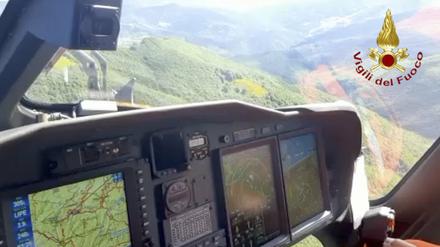 Ein italienischer Feuerwehrhubschrauber sucht die Absturzstelle eines Hubschraubers ab. Sieben Menschen haben bei einem Hubschrauberunglück im italienischen Apennin-Gebirge ihr Leben verloren. 