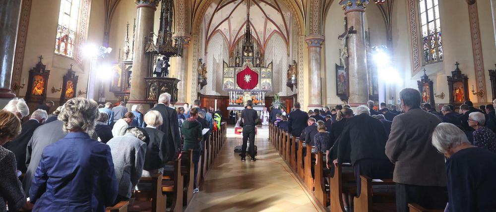 Besucher stehen bei einem Trauergottesdienst für die Opfer des Zugunglücks in der Pfarrkirche Maria Himmelfahrt.