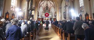 Besucher stehen bei einem Trauergottesdienst für die Opfer des Zugunglücks in der Pfarrkirche Maria Himmelfahrt.