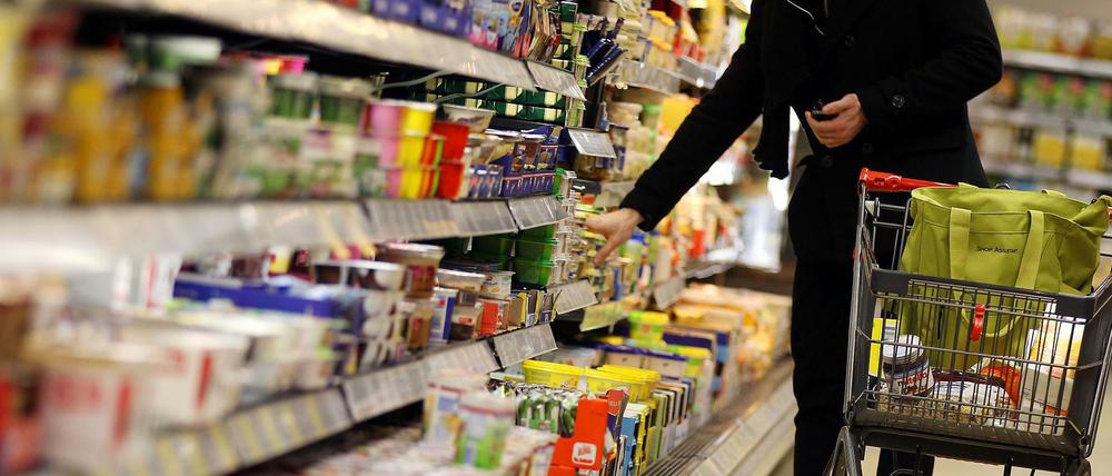 Ein Kunde steht vor einem Supermarktregal.