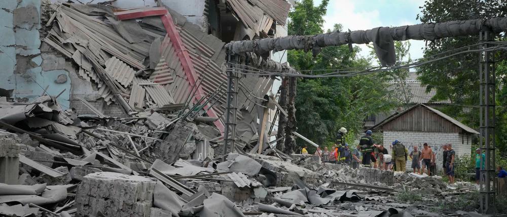 Rettungskräfte und Anwohner nach einem russischen Luftangriff auf Lyssytschansk an den Trümmern eines Gebäudes. 