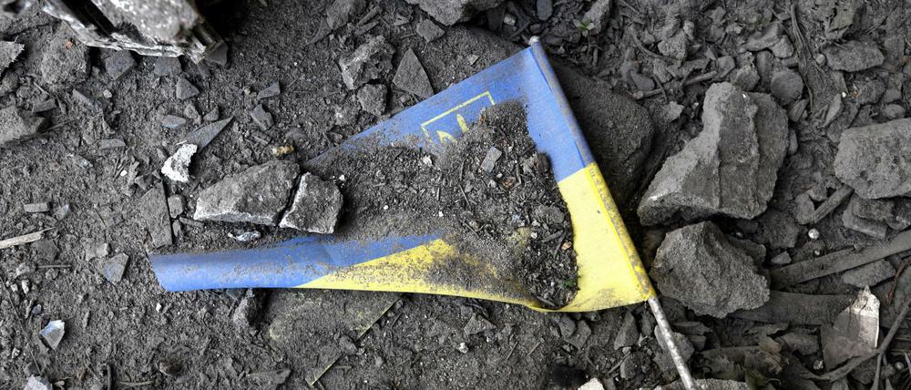 02.06.2022, Ukraine, Charkiw: Eine ukrainische Fahne liegt nach einem Raketeneinschlag in den Trümmern. Beim Einschlag einer russischen Rakete in eine Schule in der ukrainischen Stadt Charkiw wurden am 02.06.2022 eine Frau getötet und mehrere Personen verletzt.