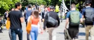 Studierende gehen in Gruppen über den Campus einer Universität.