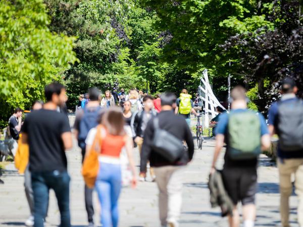 Studierende gehen in Gruppen über den Campus einer Universität.
