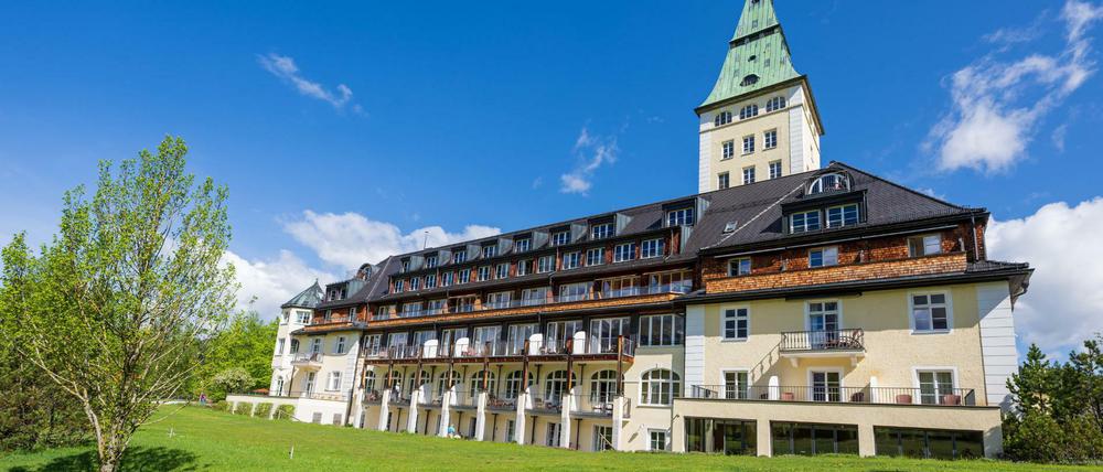 Satte Wiesen im Sonnenschein. Mitten darin liegt das Tagungshotel Schloss Elmau. Foto: Peter Kneffel/dpa