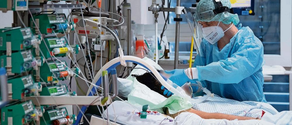 Ein Intensivpfleger kümmert sich in der Uniklinik Gießen um einen Covid-19-Patienten.