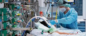 Ein Intensivpfleger kümmert sich in der Uniklinik Gießen um einen Covid-19-Patienten.