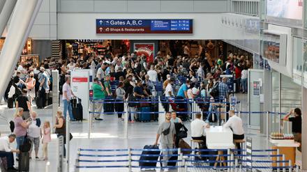 Passagiere stehen an Check-In Schalter der jeweiligen Airlines am Flughafen Düsseldorf an. 