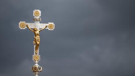 Mai 2022: Ein Kruzifix ist beim Schlussgottesdienst des 102. Deutschen Katholikentags vor dunklen Wolken zu sehen.