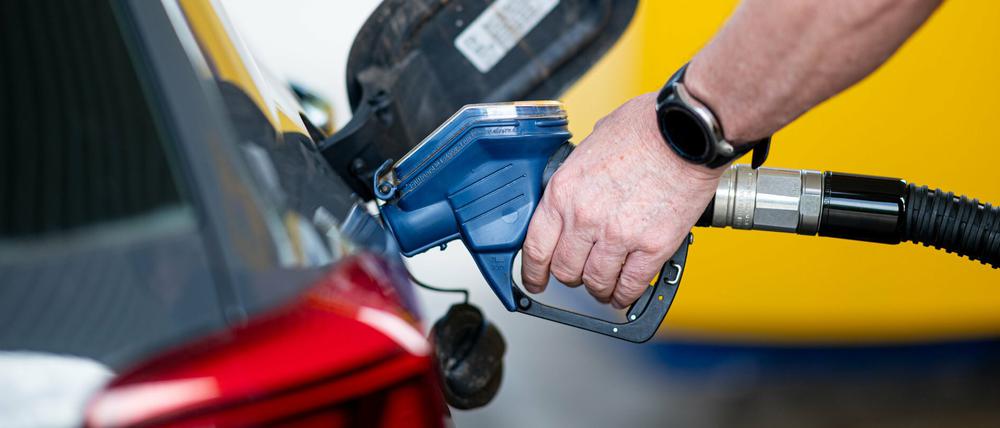 Ein Mann betankt an einer Tankstelle sein Auto.