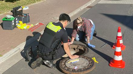 Polizisten untersuchen in Oldenburg den Gully, aus dem Joe geborgen wurde.