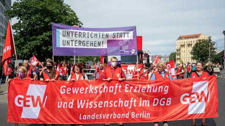 Teilnehmer:innen der Demonstration der Gewerkschaft Erziehung und Wissenschaft (GEW) tragen ein Plakat mit der Aufschrift «unterrichten statt untergehen!». 