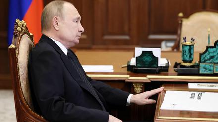 Der russische Präsident Wladimir Putin sitzt während einer Telefonkonferenz an seinem Schreibtisch in Moskau. 