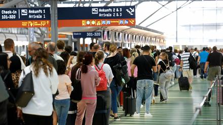 Passagiere stehen in einer Schlange von mehreren hundert Metern für die Sicherheitskontrolle am Flughafen Köln-Bonn an.