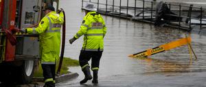 Mitglieder der örtlichen Feuerwehr arbeiten an einer überfluteten Sportstätte in Camden am Stadtrand von Sydney.