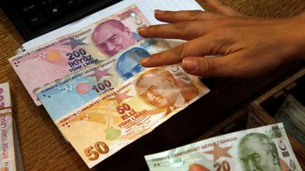 Ein Mitarbeiter einer Wechselstube zählt türkische Lira-Banknoten (Archivbild).