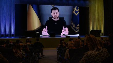 Der ukrainische Präsident Wolodymyr Selenskyj erscheint auf einem riesigen Bildschirm, während er zu Beginn einer zweitägigen internationalen Konferenz über den Wiederaufbau der Ukraine in Lugano am 4. Juli 2022 eine Erklärung abgibt.
