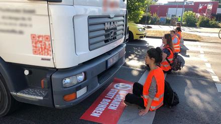 Aktivist:innen blockieren eine Straße in Berlin. 