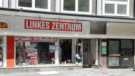 Nach einer Explosion, von der auch ein Parteibüro der Linken betroffen ist, liegen noch Splitter und Trümmer auf dem Gehweg.