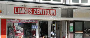 Nach einer Explosion, von der auch ein Parteibüro der Linken betroffen ist, liegen noch Splitter und Trümmer auf dem Gehweg.