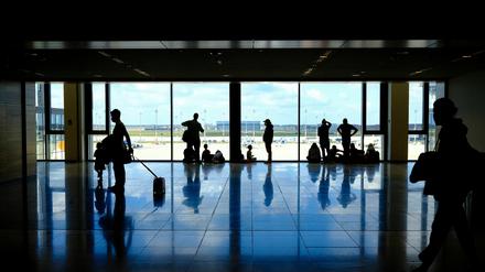 Wartende Flugpassagiere in dem Wartebereich des Terminals im BER Flughafens. 