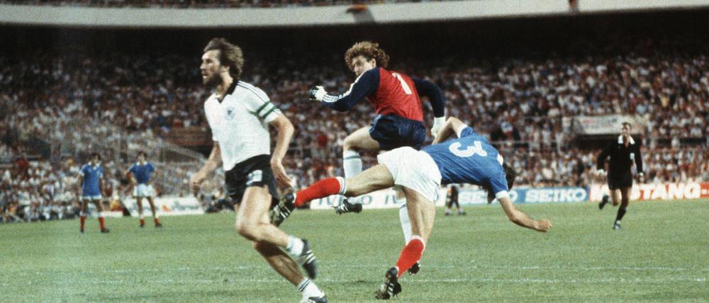 Toni Schumacher (Mi.) rammt Patrick Battiston zu Boden. Links im Bild Manfred Kaltz. 