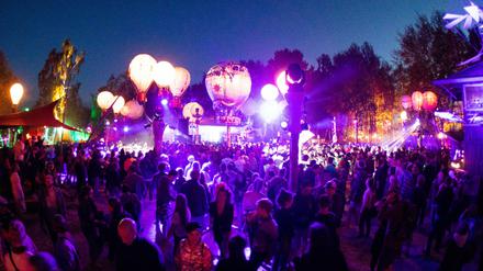 Festivalbesucher tanzen auf einer Bühne auf dem Gelände des Fusion-Festival (Archiv). Seit 1997 findet es auf dem ehemals sowjetischen Militärflugplatz Lärz statt. 