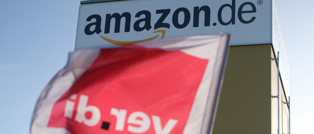 Eine Verdi-Fahne an einem Zaun des Logistik-Zentrums von Amazon.