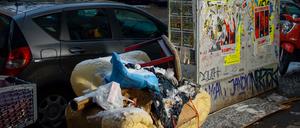 Ein alter Sessel und diverser Müll auf einem Gehweg in Berlin-Neukölln.