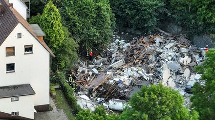 Feuerwehrleute untersuchen die Trümmer eines eingestürzten Hauses.